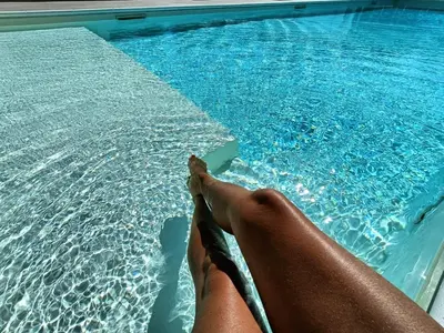 a person laying on the edge of a swimming pool at Villa Flo in Castellammare del Golfo