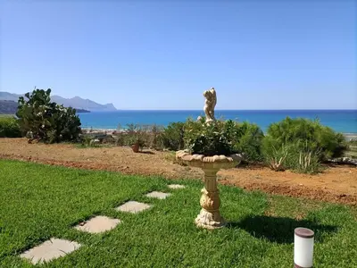 a bird bath with a cat sitting on top of it at Villa Flo in Castellammare del Golfo