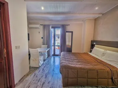 a hotel room with a bed and a table and chairs at Kunesias B&B in Cinisi