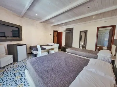 a hotel room with two beds and a table at Kunesias B&B in Cinisi