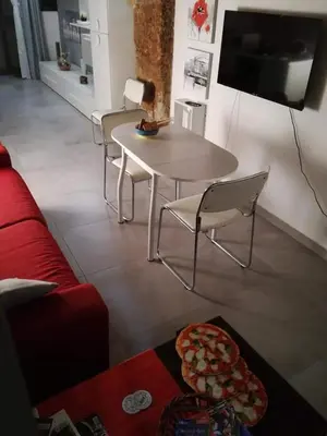 a living room with a table and chairs and a tv at La Casetta Di Marta ai Quattro Canti in Palermo