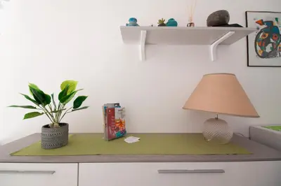 a table with a lamp and a plant on it at Porta Nuove Vacanze in Palermo