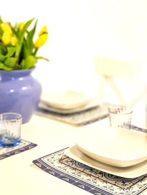 a table with plates and a vase with a plant at Il Grazioso Giardinaccio in Palermo