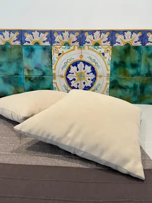 two pillows on a bed in front of a wall at Casa vacanze Al porticciolo romantico in Trappeto