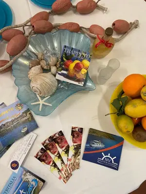 a table topped with pictures of food and a bowl of fruit at Casa vacanze Al porticciolo romantico in Trappeto