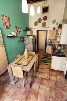 a kitchen with a table and chairs and a refrigerator at Vista Cattedrale in Palermo