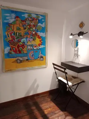 a painting hanging on a wall next to a chair at Casa Sicana in Palermo