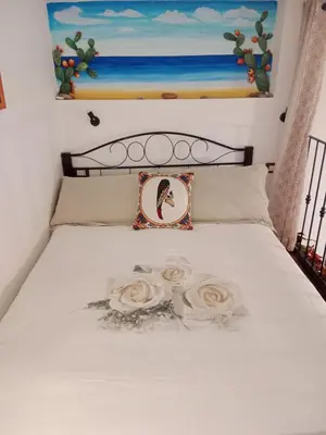 a bed with two roses and a picture on it at Casa Sicana in Palermo