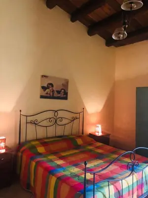 a bedroom with a bed with a colorful blanket at Agriturismo Ilardo in Collesano