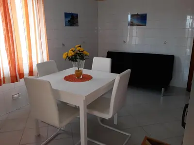 a white table with white chairs and a vase of flowers on it at casaLiuccia in Mondello