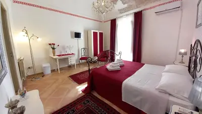 a bedroom with a large bed with a red blanket at Palazzo Cutelli Bed&Book in Palermo