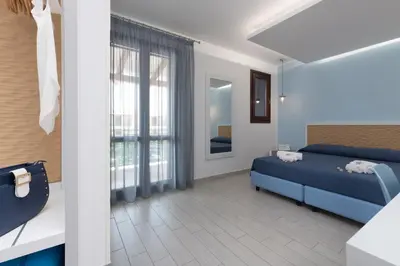 a room with a blue bed and a window at B&B Reset confort & relax in San Vito lo Capo