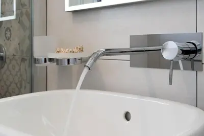 a bathroom with a faucet pouring water from a sink at B&B Reset confort & relax in San Vito lo Capo