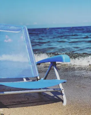 a blue beach chair sitting on the beach at Sea Pearl in Casteldaccia