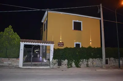 a yellow house with a gate in front of it at Simo Amour in Lercara Friddi