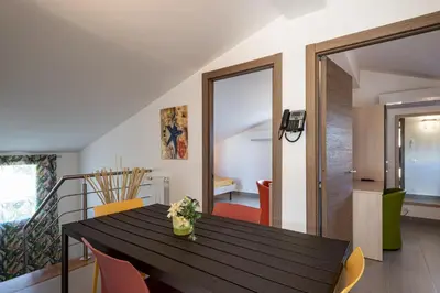 a dining room with a black table and orange chairs at Borgo Aranci - Appartamento in Villa Rosa - 16B in Castellammare del Golfo