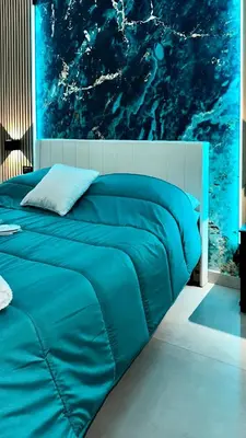 a blue bed in a bedroom with a painting at Cannatella's Mansion in Palermo