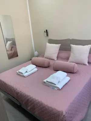 a large pink bed with towels and pillows on it at Si Viaggiare Apartments in Partinico