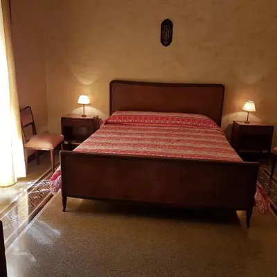 a bed in a bedroom with two night stands and two lamps at B&B SAMMARTINO in Palermo