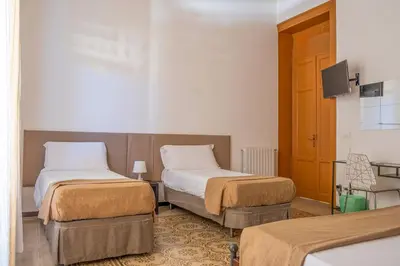 a hotel room with two beds and a tv at Ai Vicerè in Palermo