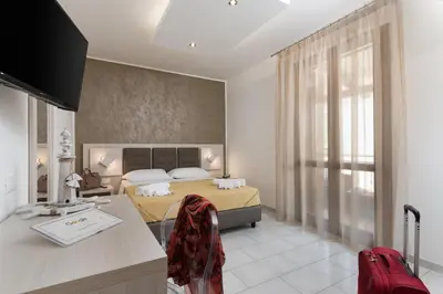 a bedroom with a bed and a red suitcase in it at La Dimora del Pescatore in San Vito lo Capo