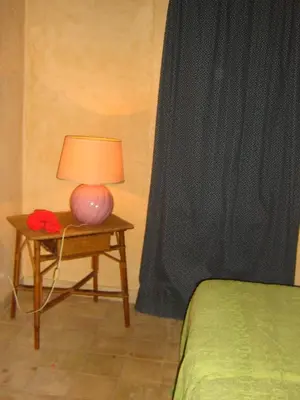 a table with a lamp on it next to a bed at the ancient sicilian house near zingaro reserve Scopello in Scopello