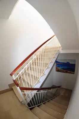 a staircase in a house with a painting on the wall at Le Sette Meraviglie in Castellammare del Golfo