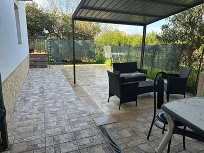 a patio with a table and chairs under a pavilion at House Cefalù 1915 in Lascari
