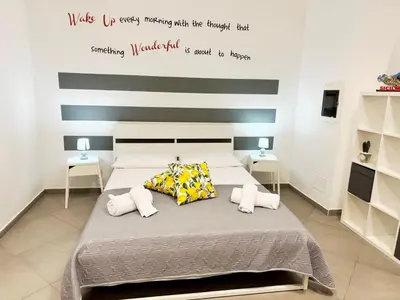 a bedroom with a bed with a striped wall at Loft in Balestrate vicino al Mare - Rental BeB in Balestrate