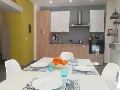 a kitchen with a table with plates and oranges on it at Cassaro Antico in Palermo