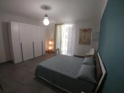 a bedroom with a bed and a large window at Cassaro Antico in Palermo
