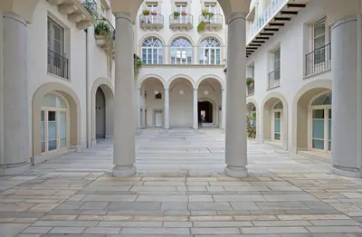 an empty courtyard of a building with columns at B&B Dimora Tomasi in Palermo