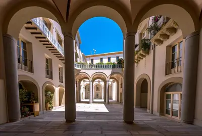 an empty arcade in a building with columns at B&B Dimora Tomasi in Palermo