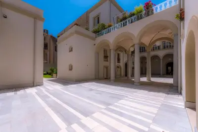 an empty courtyard of a building with arches at B&B Dimora Tomasi in Palermo