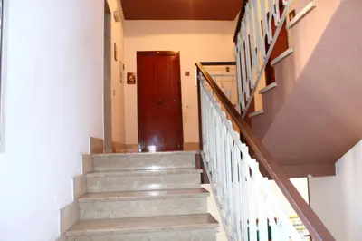 a staircase in a house with a wooden door at Casa Siciliabedda in Capaci