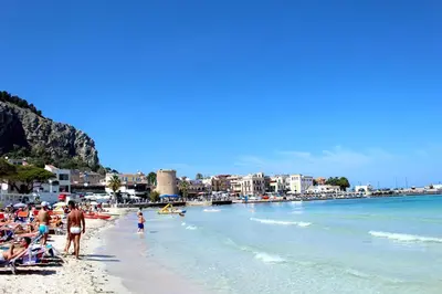 a group of people on a beach near the water at Casa Siciliabedda in Capaci