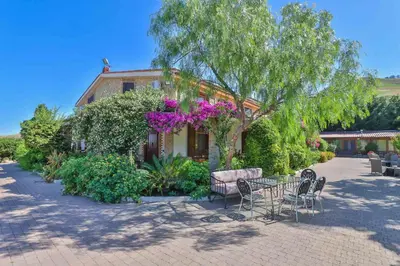 a house with a table and chairs in front of it at Al Lago Verde in Alia