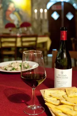 a glass of wine sitting next to a bottle of wine at Al Lago Verde in Alia