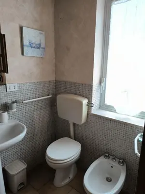 a bathroom with a toilet and a sink and a window at Casa Trinita in Castellammare del Golfo