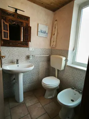 a bathroom with a toilet and a sink at Casa Trinita in Castellammare del Golfo
