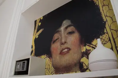 a painting of a woman next to a vase on a shelf at Palermo Gallery in Palermo