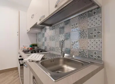 a kitchen with a sink and a stove at Rugiada Home Castellammare del Golfo in Castellammare del Golfo