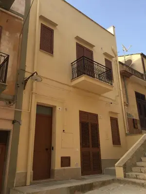 a building with a balcony and two doors and stairs at Rugiada Home Castellammare del Golfo in Castellammare del Golfo