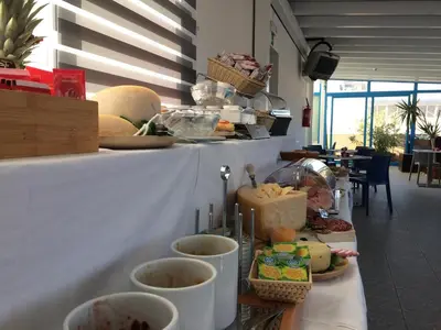 a table with cups on it with food on it at Hotel Trinacria in San Vito lo Capo