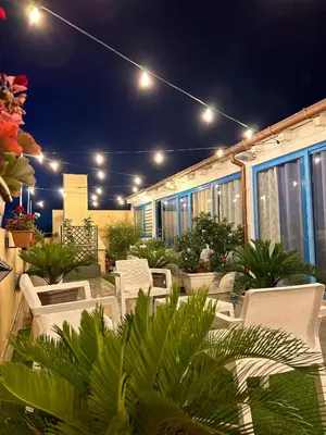 a group of chairs sitting on a patio at night at Hotel Trinacria in San Vito lo Capo