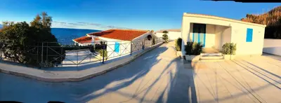 a building with a porch next to the water at Marina Beach Resort by Le Dhome Sicily in Balestrate