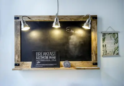 a chalkboard with a sign on a wall with lights at Palazzo Filangeri di Amorosa in Palermo