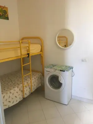 a small room with a washing machine and bunk beds at Casa Del Mulino a Vento in San Vito lo Capo