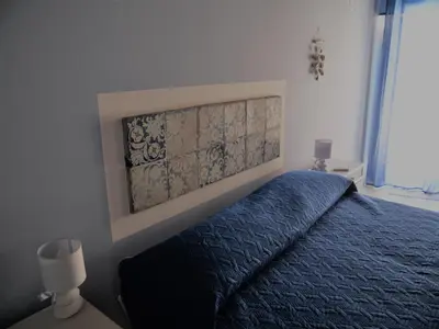a bedroom with a bed with a blue comforter at A Vanedda in Termini Imerese