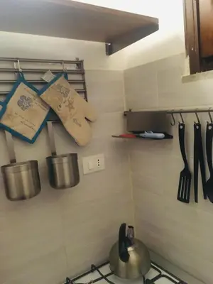 a kitchen with pots and utensils on a wall at Around Cassaro Holiday House in Palermo